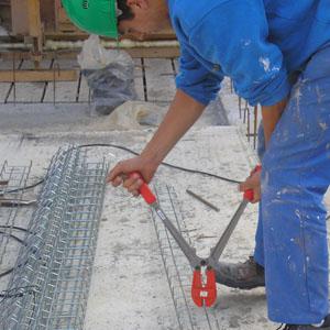 Ouvrier coupe le chemin de cable sur le chantier